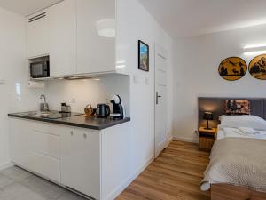 a kitchen with white cabinets and a bed in a room at Apartament Królewski w centrum Nad Łomnicą 15 in Karpacz