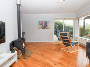 sala de estar con estufa de leña y 2 sillas en 15 Summerland Avenue, en Dawlish