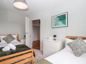 Un dormitorio con dos camas y un espejo. en 15 Summerland Avenue, en Dawlish