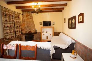 a room with two beds and a living room with a fireplace at Viviendas Turísticas El Mero in Zahora