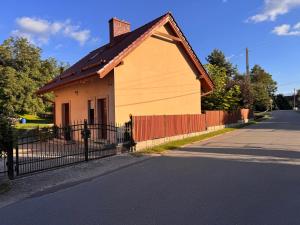 JarnołtówDomek Rychleby的路边有篱笆的小房子