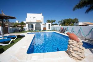a swimming pool in front of a house at Viviendas Turísticas El Mero in Zahora