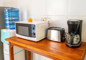 a microwave sitting on a wooden counter next to a blender at villa restu 2 in Ubud
