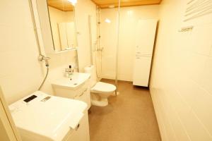 Un baño blanco con inodoro y lavabo. en Central and Spacious Apartment for 4 with Sauna, en Äänekoski