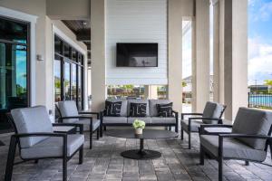 a patio with chairs and a tv on a wall at Stylish Golf Course Coach Home in Ave Maria in Harker