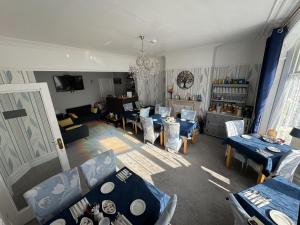 a living room with blue tables and chairs at Rossdene House in Blackpool