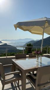 a table and chairs with an umbrella on a balcony at villa Loya in Ortaca