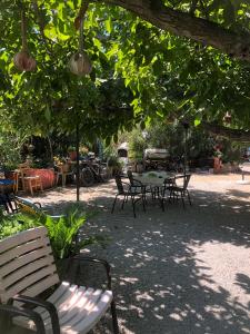 a park with a table and chairs under a tree at Guesthouse Karidia in Skala Eresou