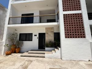 una casa bianca con scale e balcone di Departamentos DOS21 a Mazatlán