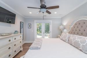 una camera da letto con un letto e un ventilatore a soffitto di 8 Deer Run Lane - Sea Pines Beach And Golf a Hilton Head Island Altre 25 foto