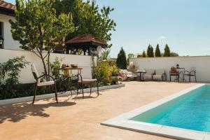 a patio with tables and chairs next to a swimming pool at House Milovanovic in Soko Banja