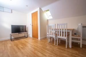 a living room with a dining table and a television at Newly Renovated Sanctuary for 4 in Charlotte House in Ipswich