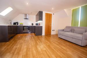 a living room with a couch and a kitchen at Newly Renovated Sanctuary for 4 in Charlotte House in Ipswich