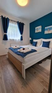 a bedroom with a large bed with blue walls at Éden Pihenőház in Veresegyház +89 photos