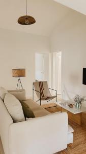 een woonkamer met een witte bank en een tafel bij Casa do Miradouro in Évora