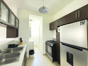 una cocina con fregadero y refrigerador en Comfort and style, en San Salvador