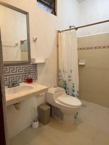 a bathroom with a toilet and a sink and a shower at GalHaus in Bacalar
