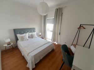 a white bedroom with a bed and a window at Martins' Happy Home in Coimbra +5 photos