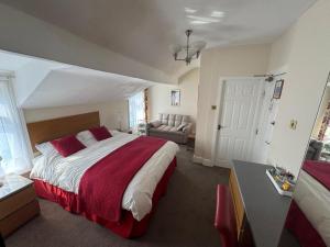 a bedroom with a large bed and a couch at Rossdene House in Blackpool