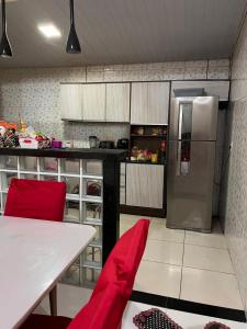 a kitchen with a stainless steel refrigerator and a table at Casa in Ananindeua