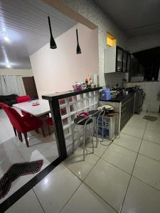 a kitchen with a counter and a table and chairs at Casa in Ananindeua