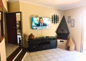 Una sala de estar con un televisor de pantalla plana en la pared. en Zinkwazi Beach Access, en Zinkwazi Beach