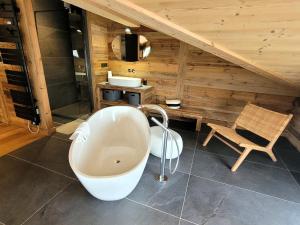 une salle de bain avec une baignoire et un lavabo dans l'établissement Chalet de luxe avec SPA, sauna, parking, WiFi et animaux admis - FR-1-598-41, aux Gets