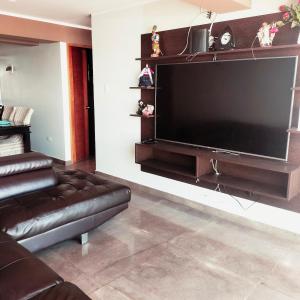 a living room with a large flat screen tv on a wall at Casa Hogar Andina Huancayo - San Carlos 3 in Huancayo