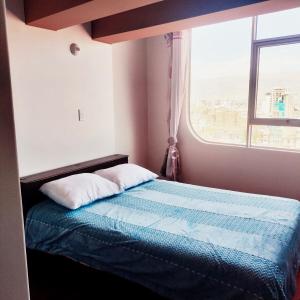 a bed in a room with a window at Casa Hogar Andina Huancayo - San Carlos 3 in Huancayo