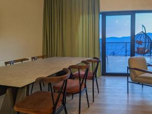 ein Esszimmer mit einem Tisch und Stühlen sowie einem Balkon in der Unterkunft High Gudauri - Ski in ski out - loft with terrace in Gudauri + 22 Fotos