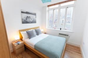 a bedroom with a bed and a window at Farringdon Apartments in London