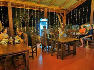 a group of people sitting at tables in a restaurant at Inpan's beach resort Batticaloa in Batticaloa