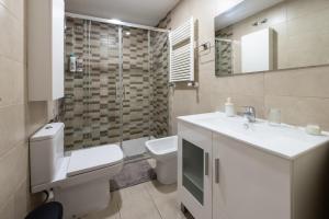 Un baño con inodoro, lavabo y espejo. en Maravilloso piso en Getafe, Madrid, en Getafe 14 fotos más
