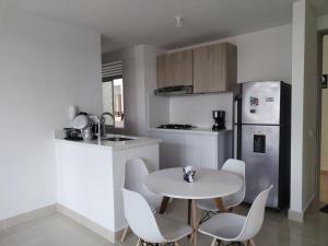 a kitchen with a table and chairs and a refrigerator at Brisas la aldea in Ricaurte