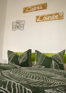 a bed with green and white pillows on it at Ferienwohnung Altstadtstube in Annaberg-Buchholz