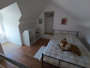 a bedroom with a bed with a teddy bear on it at la ferme du renard et son gîte 