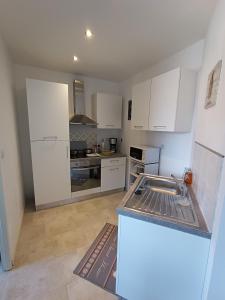 a kitchen with white cabinets and a counter top at la ferme du renard et son gîte 