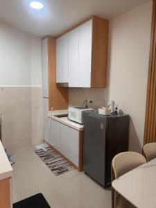 a small kitchen with a microwave and a refrigerator at Coco homes Seaview 4 pax at The Shore A0712 in Kota Kinabalu