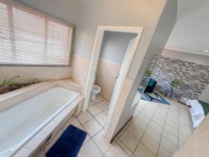 a bathroom with a tub and a toilet at De'Lush Oasis in Pretoria +30 photos