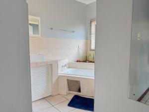 a white bathroom with a tub and a sink at De'Lush Oasis in Pretoria +25 photos