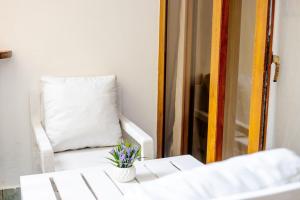 乌昆达LILAC Beachfront 1bedroom Apartment的白色椅子,带枕头和花瓶