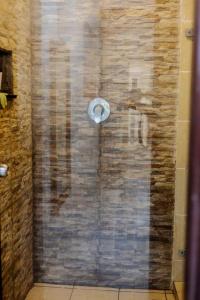 乌昆达LILAC Beachfront 1bedroom Apartment的带淋浴的浴室(带石墙)