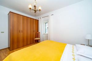 una camera da letto con un letto grande e un armadio in legno di Apartment Vinka near the beach a Postira (Postire)
