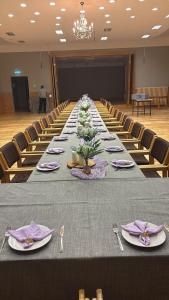 a long table in a large room with chairs at Atpūtas komplekss Cerības 