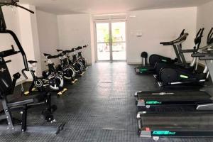 a gym with a row of treadmills and exercise bikes at Brisas la aldea in Ricaurte