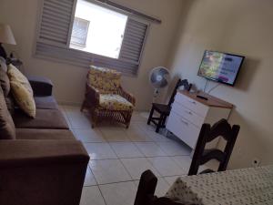 a living room with a couch and a tv at O coração de Ubatuba in Ubatuba