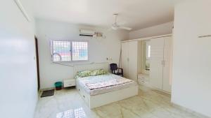 a white bedroom with a bed and a window at ELO House - Spacious 2BHK Apartment with Kitchen, Malleswaram in Bangalore