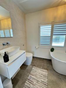 a bathroom with a tub and a sink and a mirror at Amazing City Centre Home in Derby +22 photos