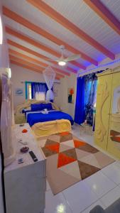 a bedroom with a bed and a checkerboard floor at Secrète Paradise in Capesterre-Belle-Eau