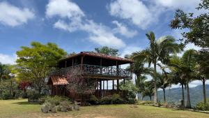 a resort building with a balcony and palm trees at Reserva Natural Origen Alojamiento Campestre in San Rafael +19 photos
